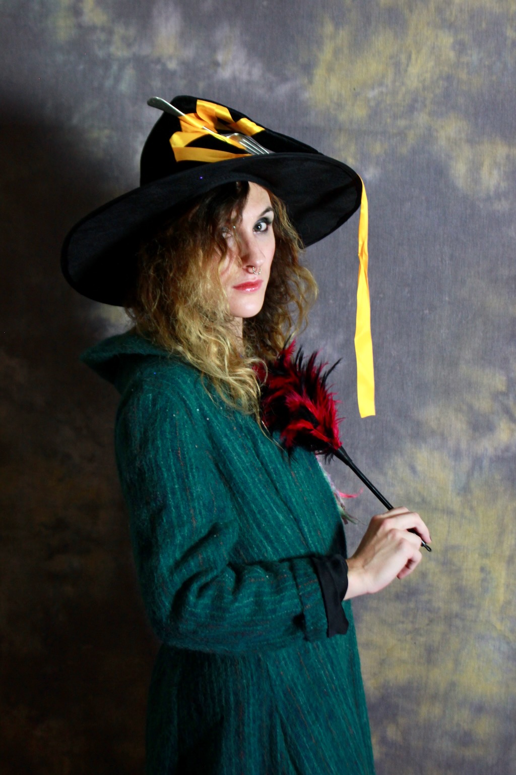 person wearing green overall, with wizard hat featuring a fork