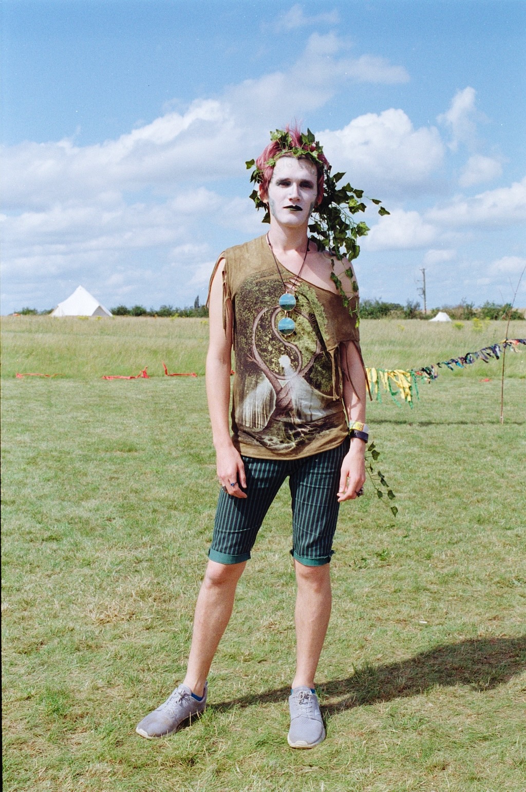 Person standing in a field with a flower crown